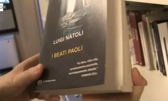 Mani che sfogliano "I Beati Paoli" di Luigi Natoli, un libro che promette narrazione avvincente e analisi sociologica.