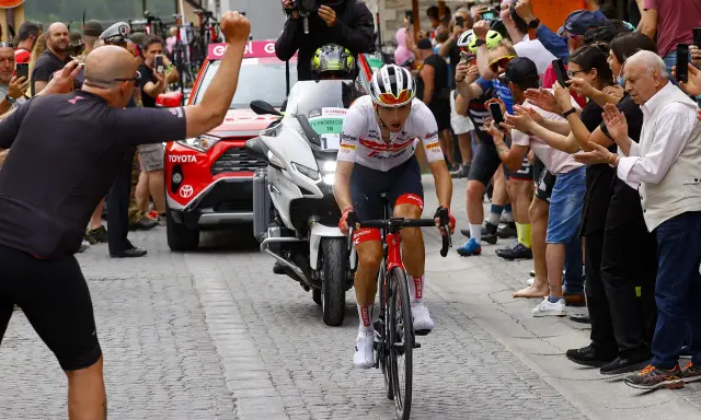 Giulio Ciccone fährt auf seinem Rennrad durch eine Gasse, umgeben von jubelnden Zuschauern und Motorrädern.