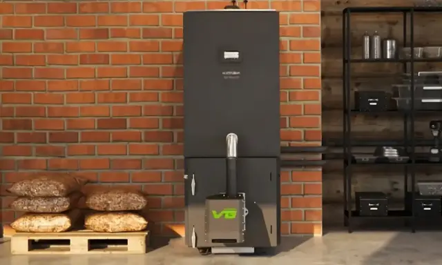 Nowoczesny piec na pellet z zielonym logo VG. Obok paleta z workami pelletu. Dofinansowanie na piec na pellet pomoże obniżyć koszty ogrzewania.