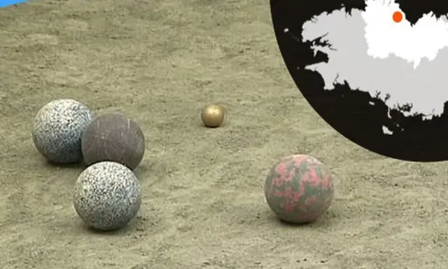 Terrain de jeu pour la boule bretonne, avec des boules de différentes matières et couleurs. Une carte de la Bretagne est visible en arrière-plan.