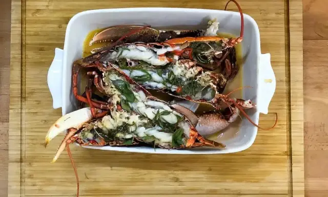 Homards bleus préparés dans un plat blanc, prêts pour une recette savoureuse.