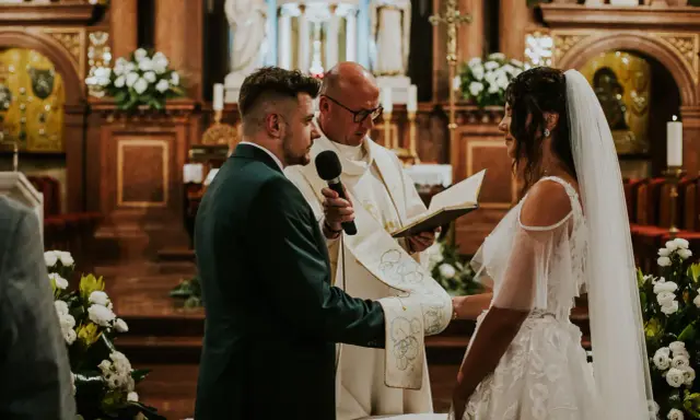 Para Młoda w kościele, kapłan czyta z księgi. Ślub kościelny to sakrament, który daje łaskę i błogosławieństwo.