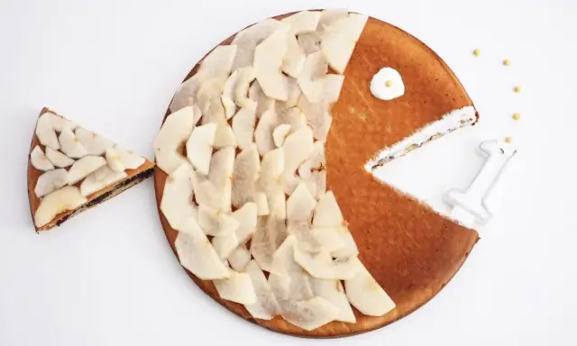 Gâteau en forme de poisson pour enfant, décoré de fines tranches de poire. Une part a été retirée, comme si le poisson mangeait.