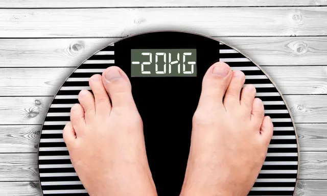 Pieds sur une balance affichant -20kg. Un résultat impressionnant obtenu en jeunant.