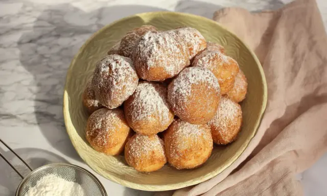 Stosik pysznych, puszystych pączków posypanych cukrem pudrem. Idealne na tłusty czwartek, te fit pączki wyglądają apetycznie.