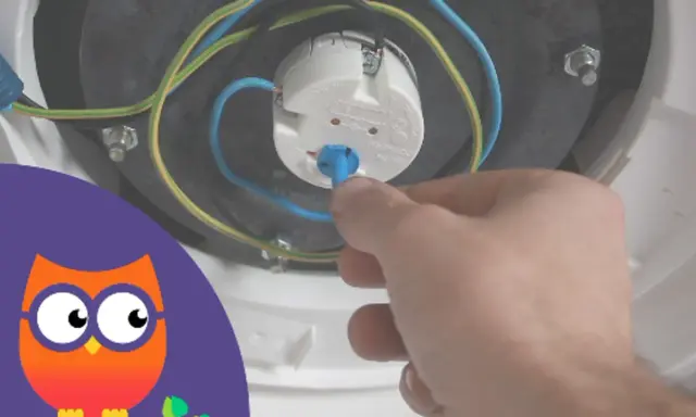 Main tenant ajuste le thermostat du chauffe-eau.