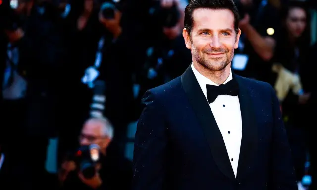 Bradley Cooper smiles, sporting a classic tuxedo. This image confirms that black tie does indeed mean tuxedo.