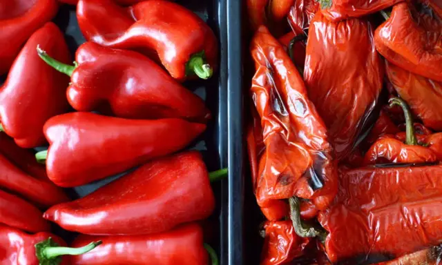 Dos recipientes llenos de pimientos rojos. A la izquierda, pimientos frescos y brillantes. A la derecha, pimientos asados, con la piel arrugada y un tono más oscuro.