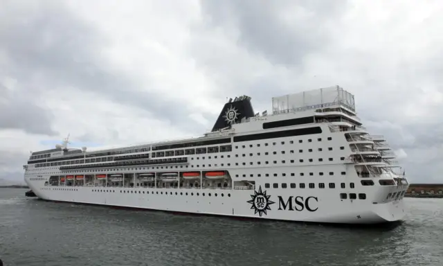 La MSC Sinfonia, con la sua impressionante lunghezza, solca le acque grigie sotto un cielo nuvoloso.