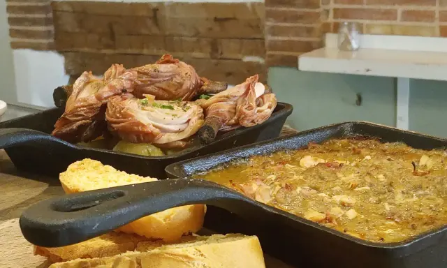 Deliciosa comida típica de Cuenca: pollo asado y un guiso con pan.