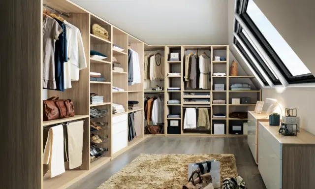 Un dressing bien organisé pour savoir comment ranger son dressing : vêtements suspendus, étagères remplies, tiroirs et accessoires à portée de main.