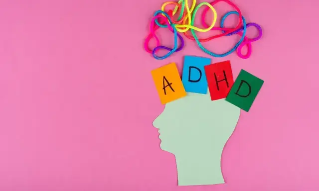 Kolorowe sznurki nad głową symbolizują chaos myśli. Kartki z literami A, D, H, D układają się w napis ADHD. To wizualizacja tego, czym jest autyzm.
