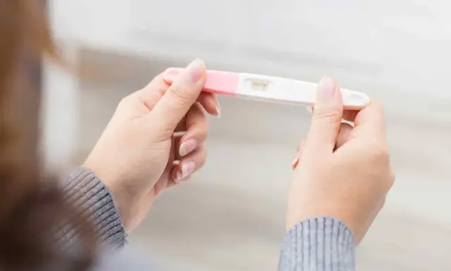 Kvinna håller graviditetstest. Ett streck syns, vilket indikerar negativt resultat, trots att hon känner sig gravid i vecka 7.