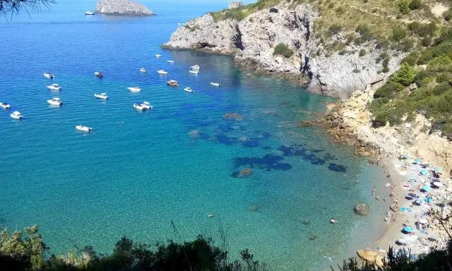 La **cala del gesso spiaggia** è un gioiello incastonato tra rocce e macchia mediterranea. Acque cristalline e barche ormeggiate invitano al relax.