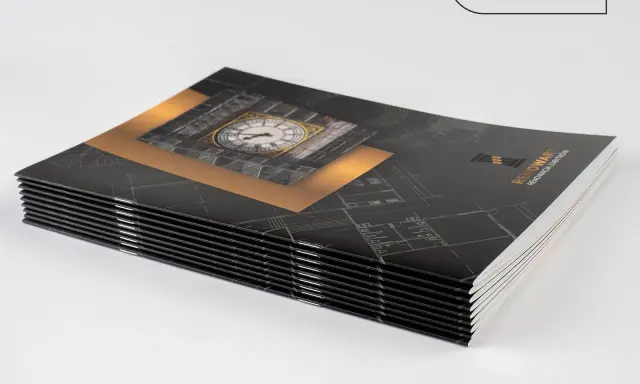 Stos eleganckich broszur reklamowych inaczej, z motywem zegara i planów architektonicznych.