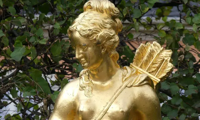 Statue dorée d'Artémis, déesse de la chasse, portant un carquois rempli de flèches sur son épaule.