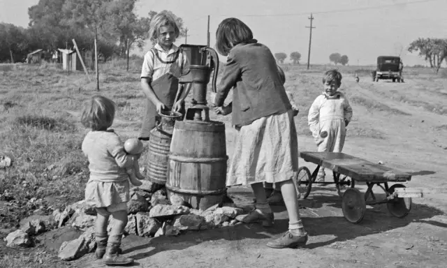 Bambini alla pompa dell'acqua, un'istantanea di Dorothea Lange che cattura la vita quotidiana.
