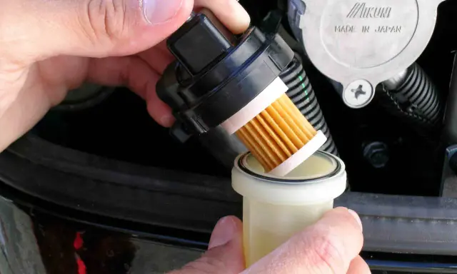 Maintenant, je procède au changement du filtre à gasoil. Le nouveau filtre est prêt à être installé.