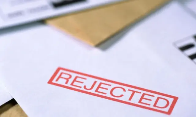 Czerwony stempel "REJECTED" na dokumencie, który mógł być wnioskiem o pozwolenie na broń.