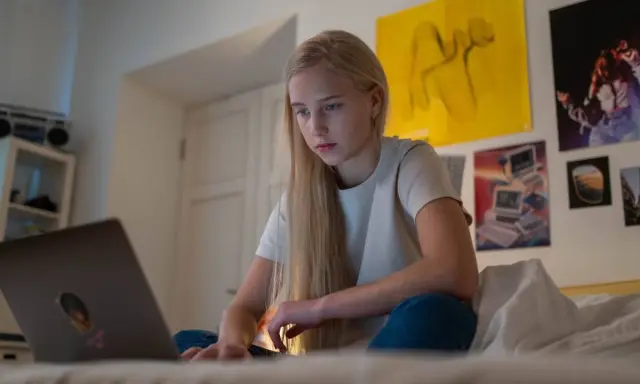 Dziewczyna szuka w internecie informacji, gdzie można pracować w wieku 16 lat.