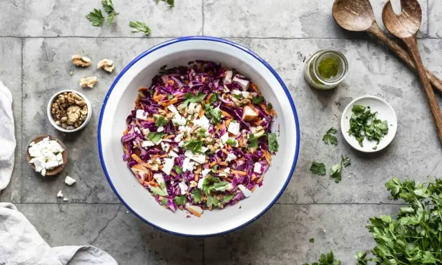 Frischer rotkohlsalat mit feta, karotten, walnüssen und Petersilie, bereit zum Servieren.