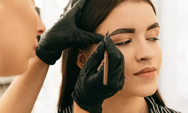 Application de henné sur les sourcils pour un regard intense.