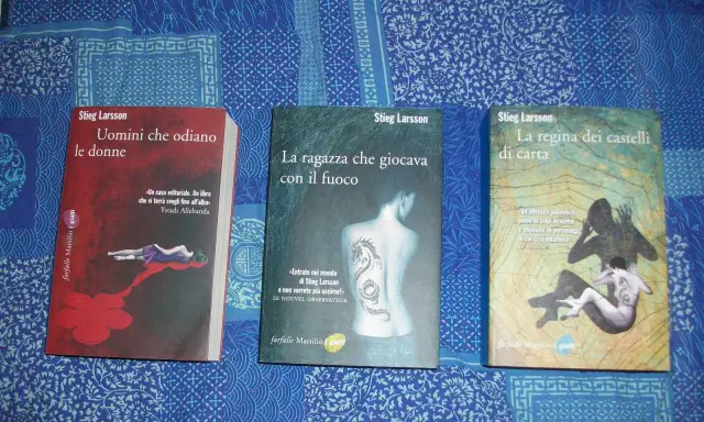 Tre libri di Stieg Larsson: "Uomini che odiano le donne", "La ragazza che giocava con il fuoco" e "La regina dei castelli di carta", parte della saga Millennium.