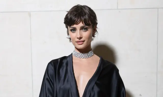Frau mit einer modernen Frisur zwischen Pixie und Bob, trägt ein schwarzes Seidenkleid und einen funkelnden Choker.