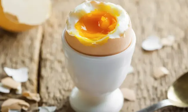 Jajko na miękko w kieliszku, z płynnym żółtkiem. Czy jajka podwyższają cholesterol? Pytanie, które nurtuje wielu.