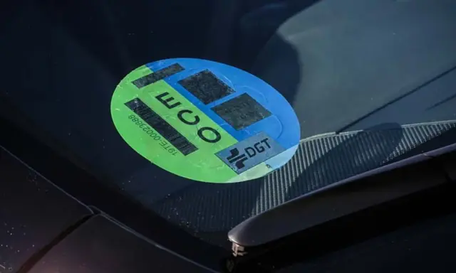 Pegatina ECO en parabrisas, indicando que es uno de los coches sin etiqueta que cumplen normativas ambientales.