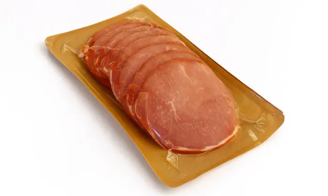 Lonchas de lomo adobado envasadas al vacío sobre una bandeja dorada.