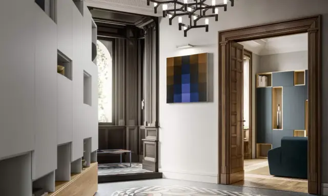Ingresso con armadiature moderne, lampadario geometrico e un quadro astratto, in un ambiente che evoca lo stile liberty moderno.