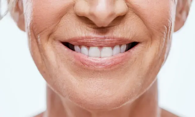 Sonrisa de mujer con piel madura, mostrando cómo disimular el surco nasogeniano con técnicas de maquillaje y cuidado facial.