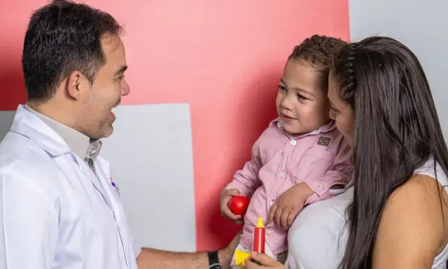 Médico habla con madre y niño, buscando entender los problemas de concentración del pequeño.