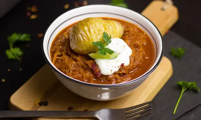 Un plat réconfortant de cuisine des terroirs aujourd'hui : choucroute garnie avec une pomme de terre Hasselback et une touche de crème.