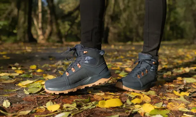 Jesienne buty trekkingowe na tle liści. Idealne, by dowiedzieć się, jak się ubrać w góry jesienią.