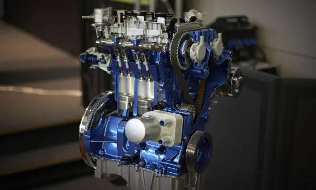 Przekrój silnika 1.0 Ecoboost w kolorze niebieskim, z widocznymi tłokami i paskiem rozrządu.
