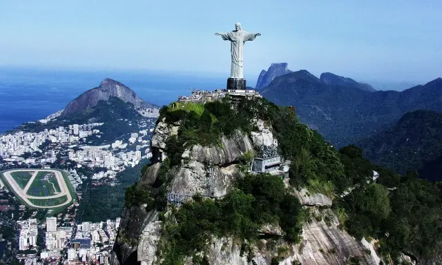 Majestatyczny pomnik Rio de Janeiro Jezus góruje nad miastem i oceanem, otoczony bujną zielenią i skalistymi szczytami.