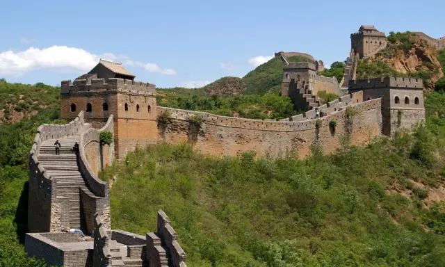 Die Chinesische Mauer, eine beeindruckende yajuj majuj location, schlängelt sich über grüne Hügel.
