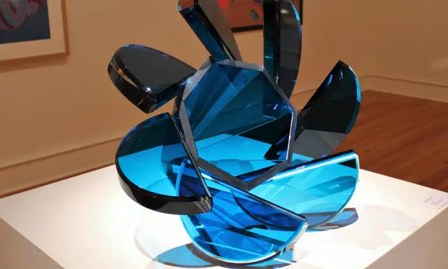 A sculpture of blue glass shards, showcasing transparency in art, with light reflecting through its facets.