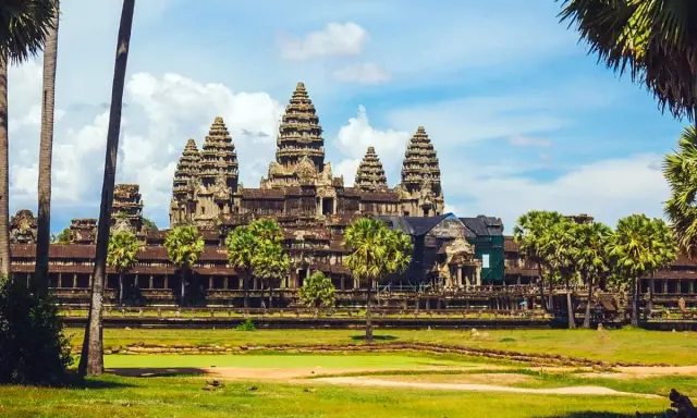 Angkor Wat, Cambodia, a majestic temple complex, bathed in sunlight. A gay couple enjoys the view, embracing the beauty of this historic site.
