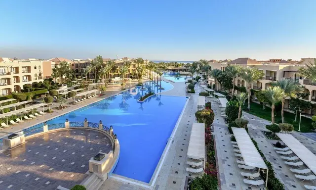 Luksusowy resort Jaz Aquamarine z basenami o turkusowej wodzie, palmami i budynkami hotelowymi.
