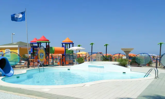 Piscina con scivolo e giochi acquatici in una giornata di sole a Cattolica, Emilia Romagna.