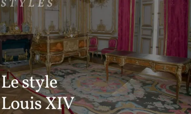 Un salon orné de mobilier Louis XIV, avec un bureau imposant et une commode dorée sur un tapis fleuri.