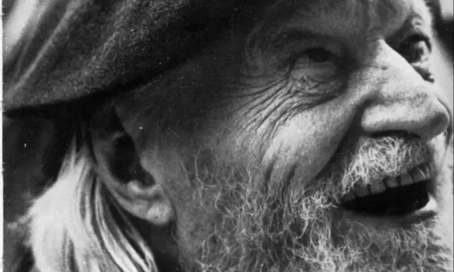 Primo piano di un uomo anziano con barba e cappello, il volto segnato dal tempo, come in un "giorno per giorno Ungaretti".