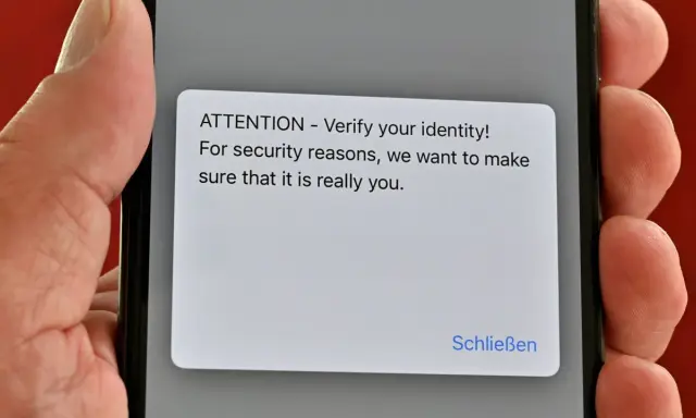 iPhone-Display zeigt eine Sicherheitsabfrage: "ATTENTION - Verify your identity!". Ein Virenscan könnte dies auslösen.