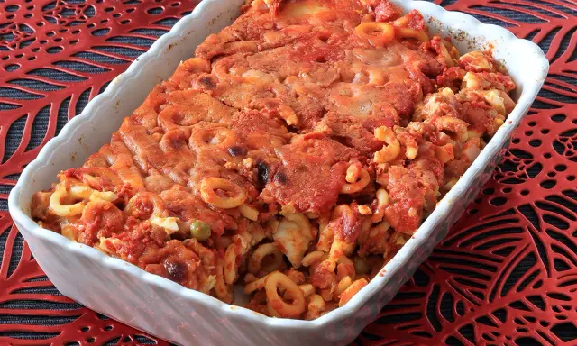 Un invitante piatto di anelletti al forno, con pasta corta condita con sugo rosso e formaggio gratinato, pronto per essere gustato.