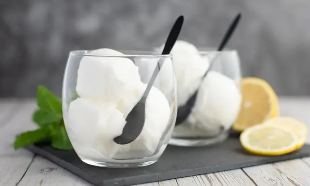 Deux verres de sorbet citron, parfaits pour un cocktail Colonel rafraîchissant, avec des quartiers de citron et de la menthe.