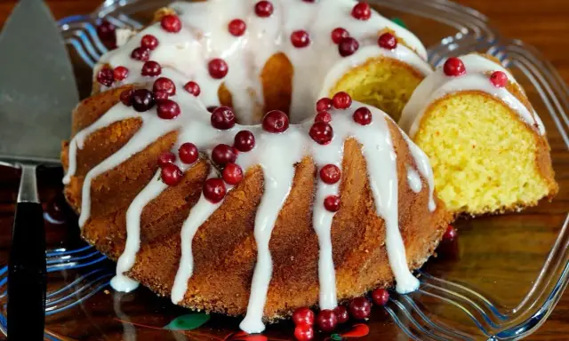 En saftig sockerkaka med vit glasyr och röda lingon, en perfekt höstkaka.