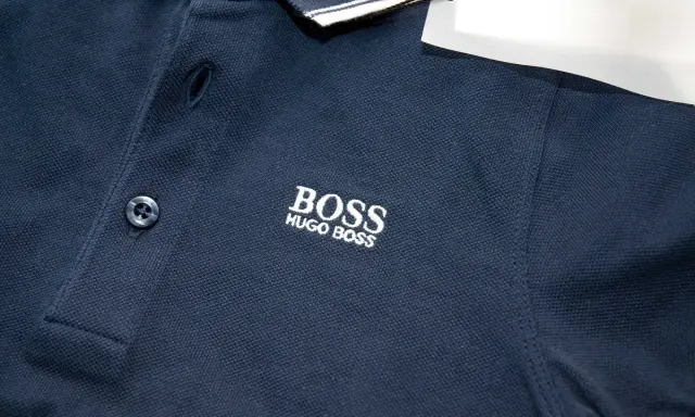 Granatowa koszulka polo z haftowanym logo BOSS HUGO BOSS. Widoczna oryginalna metka Hugo Boss.